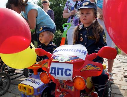 Дети на электромобилях с надписями `Милиция ДПС`.