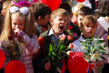 Утренняя линейка. Зевающий первоклассники с цветами.