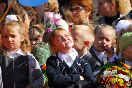 Девочка задумалась на утренней линейке.