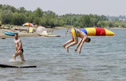 Пляж. Мужчина прыгает в воду.