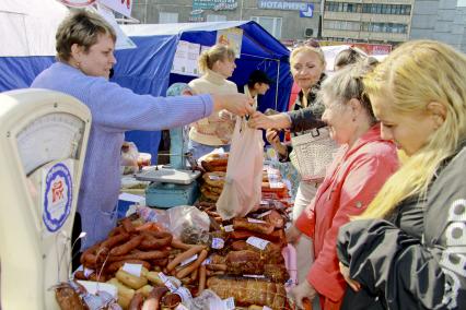 Продажа колбасы на рынке. Покупатели выбирают товар.