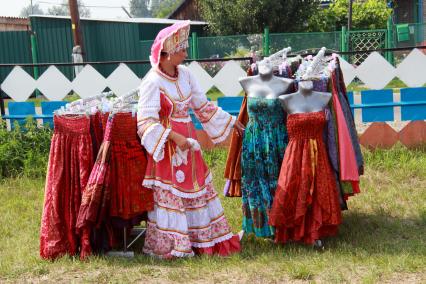 На фестивале имени Михаила Евдокимова. Женщина в народном костюме выбирает платье.