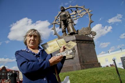 Открытие памятника переселенцам на Алтай в Барнауле. На снимке: женщина потомок первых переселенцев с фото своих предков.