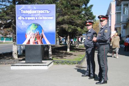 Полицейские у плаката `Толерантность - путь к миру и согласию`