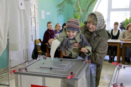 Выборы депутатов городской Думы в Барнауле. Бабушка с внуком голосуют.