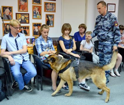 В новосибирской редакции `Комсомольской правды` в преддверии дня кинолога прошел фестиваль собак. На снимке: кинолог с собакой проводят поиск.