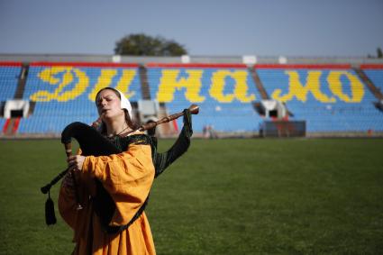 Фестиваль средневековой эпохи на стадионе `Динамо`. Девушка играет на волынке.