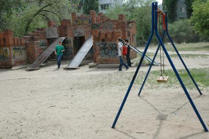 Детская площадка в Волгограде. Кирпичное здание оборудовано под детскую площадку с горками.