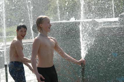 Дети играют в фонтане с водой.