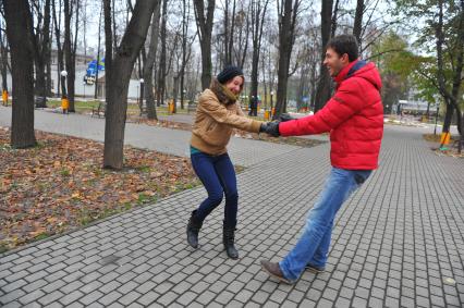 Пара гуляет в сквере