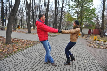 Пара гуляет в сквере