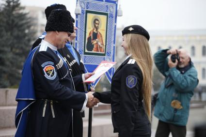 В Ставрополе на площади Ленина состоялся строевой смотр казаков Ставропольского казачьего округа Терского казачьего войска. На снимке: вручение грамоты девушке.