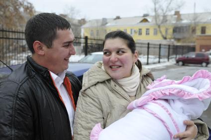 Высписка новорожденного с мамой из роддома. На снимке: Счастливые родители.