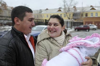 Высписка новорожденного с мамой из роддома. На снимке: Счастливые родители.