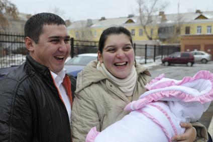 Высписка новорожденного с мамой из роддома. На снимке: Счастливые родители.