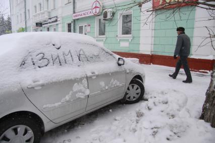 Автомобиль припорошеный снегом с надписью: `зима`.