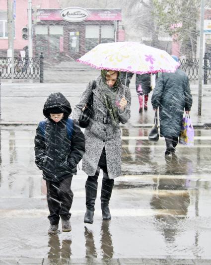 Женщина с ребенком переходят пешеходный переход.
