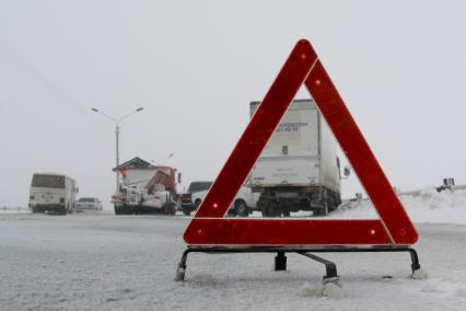 Дорожно-транспортное происшествие на загородной трассе. Знак аварийной остановки на заснеженной дороге.