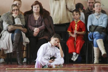 Открытый чемпионат и первенство Алтайского края по УШУ. Мальчик скучает в ожидании своего выхода.