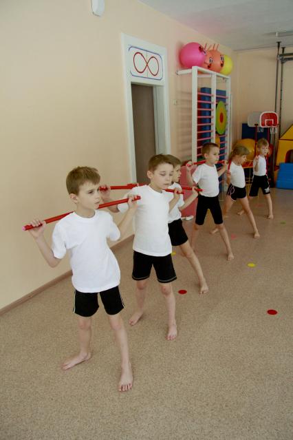 Занятия гимнастикой в детском саду. Дети выполняют упражнения.