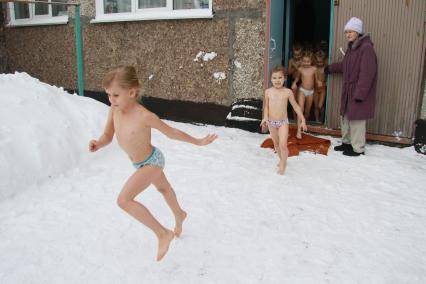 Закаливание в детском саду зимой. На снимке: дети выбегают из здания детского сада на улицу.