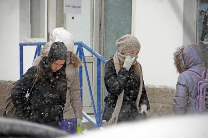 Люди в городе во время снегопада.