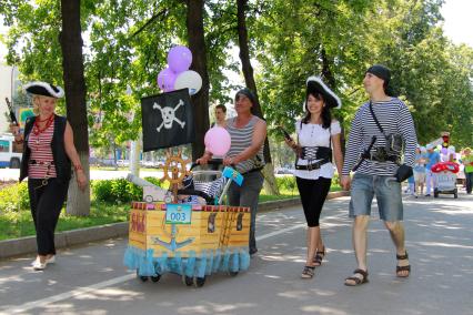 Парад детских колясок в Уфе. На снимке: Родители одеты в пиратов рядом с детской коляской в виде пиратского корабля.