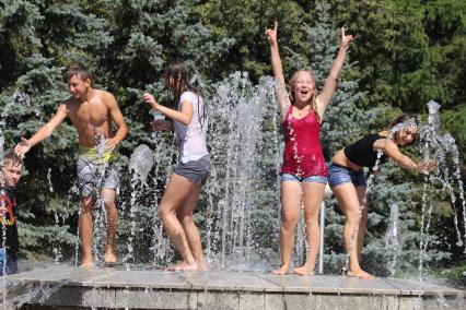 Молодежь спасается от жары в городских фонтанах.