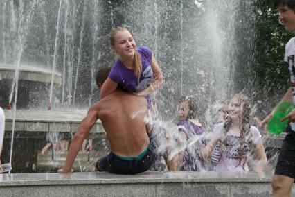 Молодежь спасается от жары в городских фонтанах.