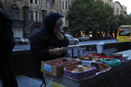 Виды Тбилиси. Проспект Шота Руставели. На снимке: женщина продает орешки и чурчхелу.
