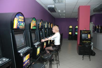 Зал игровых автоматов. На снимке: игроки сидят за игровыми автоматами.