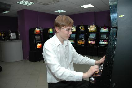 Зал игровых автоматов. На снимке: игроки сидят за игровыми автоматами.