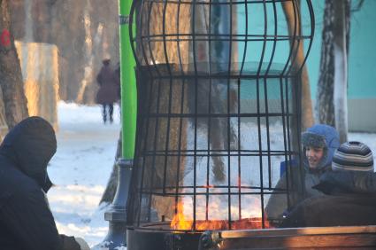 Парк Соколники. Каток `Лед`. На снимке: посетители катка согреваются у огня.