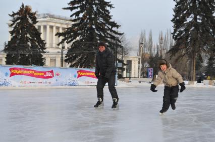 Бесплатный каток на ВВЦ. Люди катаются на коньках.