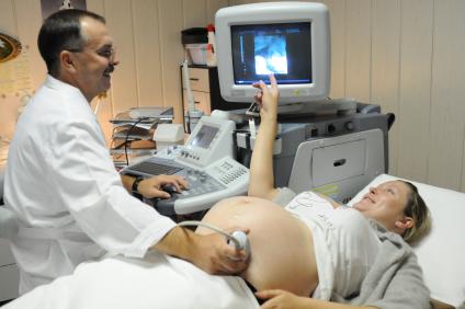 В кабинете УЗИ врач проводит ультразвуковое исследование у беременной женщины.