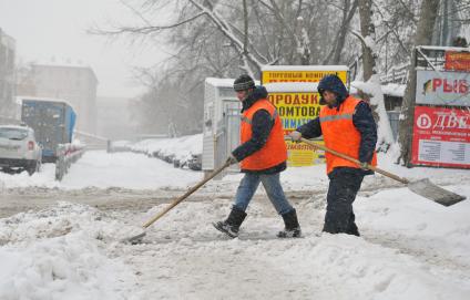 Дворники гастарбайтеры чистят улицу от снега.