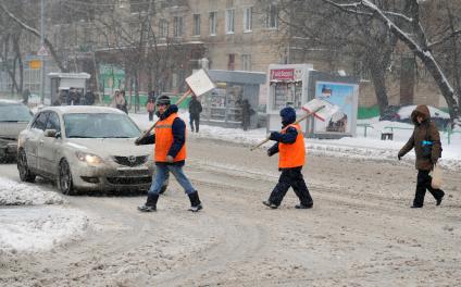 Дворники с лопатами переходят улицу.