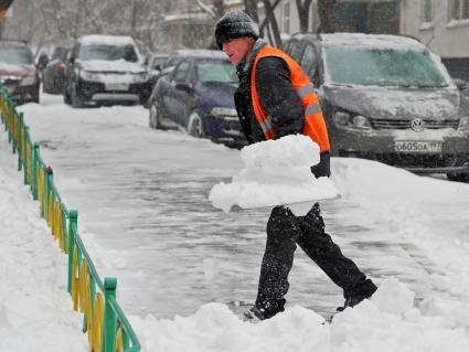Дворник чистит улицу от снега.