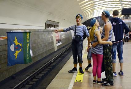 Десантник голосует в метро подняв над путями флаг.