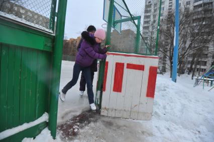 Хоккейная коробка во дворе дома. На снимке: девочки катаются на коньках