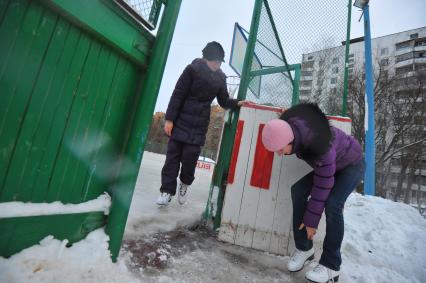 Хоккейная коробка во дворе дома. На снимке: девочки катаются на коньках