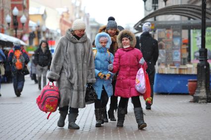 Женщина с детьми школьного возраста.