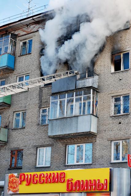 Пожар в жилом доме. Из окон валит густой дым. Вывеска магазина: `Русские блины`.