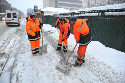 Северный округ. На снимки: дворники убирают снег.