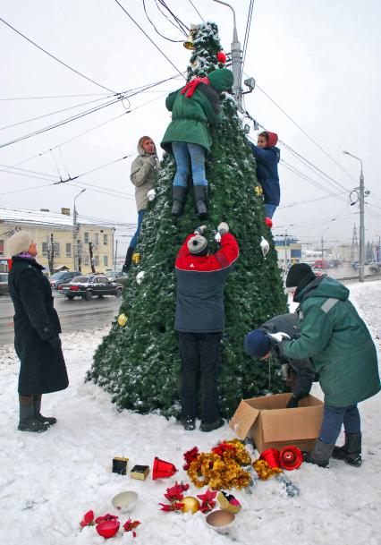 Работники ЖКХ украшают уличную елку.