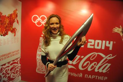 Центр фотографии имени братьев Люмьер. Выставка `Coca-Cola. Пронеси Олимпийский Огонь. Вливайся!`. Открытие. На снимке: 3-х кратная олимпийская чемпионка по синхронному плаванию Мария Киселева с факелом Олимпийских Игр 2014 в Сочи.