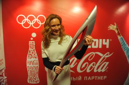 Центр фотографии имени братьев Люмьер. Выставка `Coca-Cola. Пронеси Олимпийский Огонь. Вливайся!`. Открытие. На снимке: 3-х кратная олимпийская чемпионка по синхронному плаванию Мария Киселева с факелом Олимпийских Игр 2014 в Сочи.