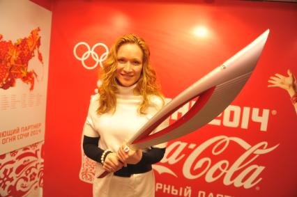 Центр фотографии имени братьев Люмьер. Выставка `Coca-Cola. Пронеси Олимпийский Огонь. Вливайся!`. Открытие. На снимке: 3-х кратная олимпийская чемпионка по синхронному плаванию Мария Киселева с факелом Олимпийских Игр 2014 в Сочи.