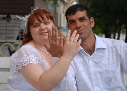 Русско-кавказская свадьба. Русская жена и муж кавказец демонстрируют обручальные кольца.