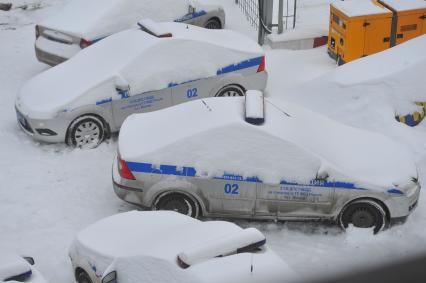 Автомобили полиции в снегу.